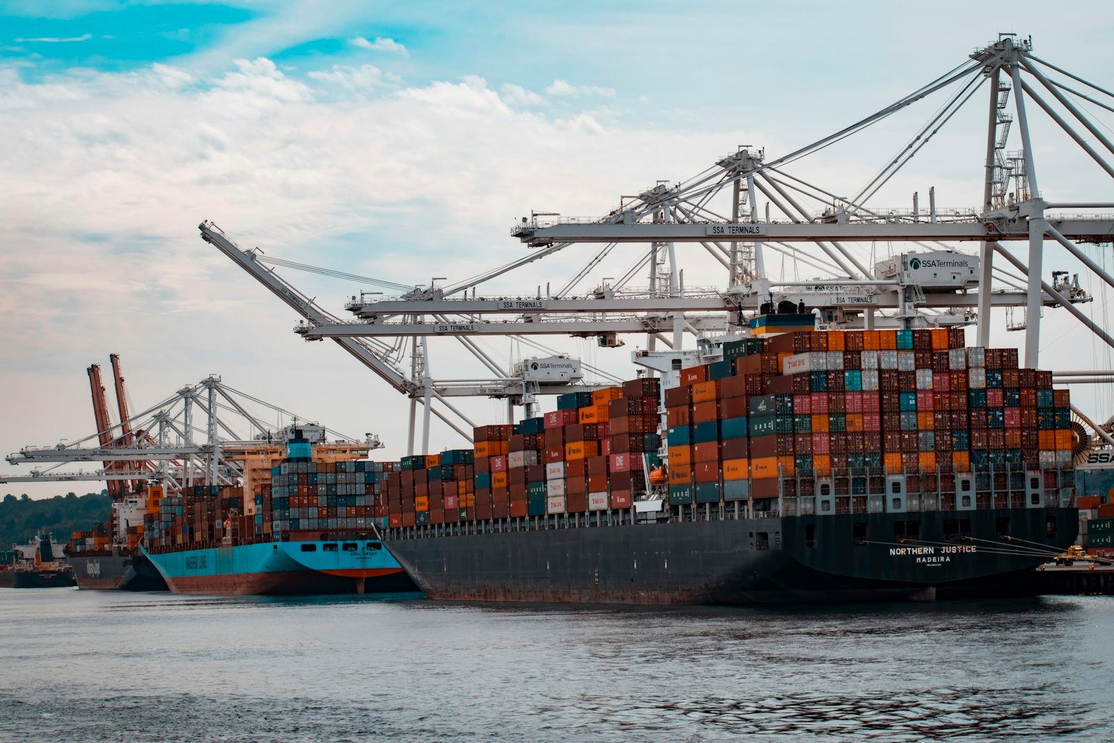 Container ships loading at berth under gantry cranes